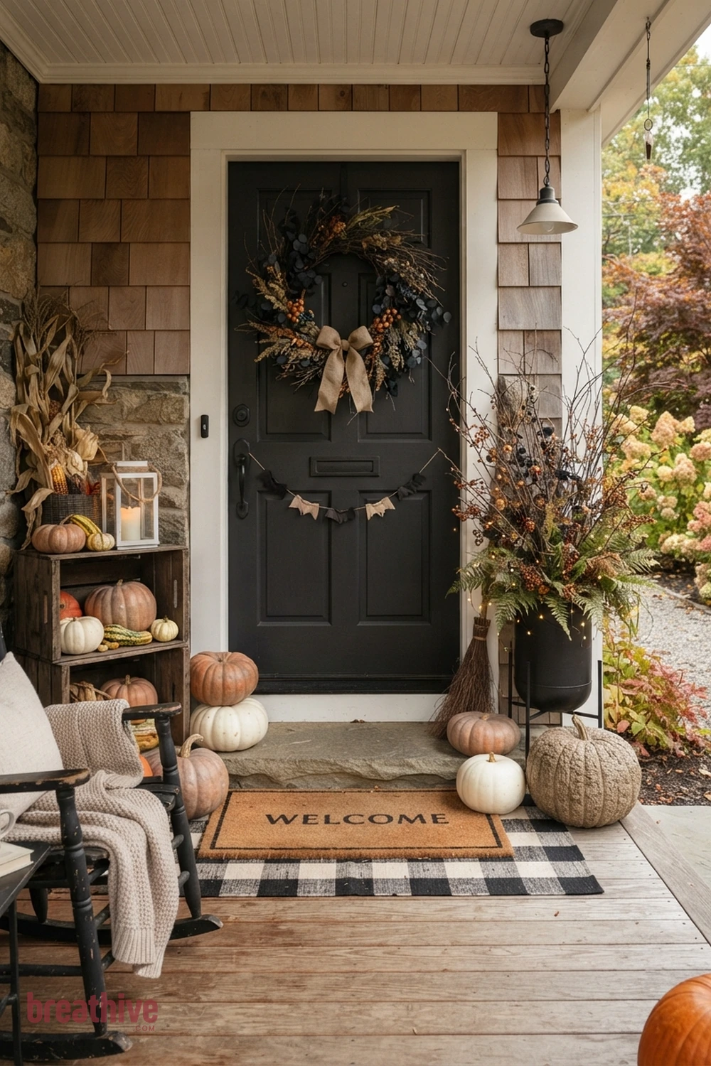 DIY polished Halloween front porch idea with front door arrangement with wreath, pumpkins, mat, and restrained vertical accents