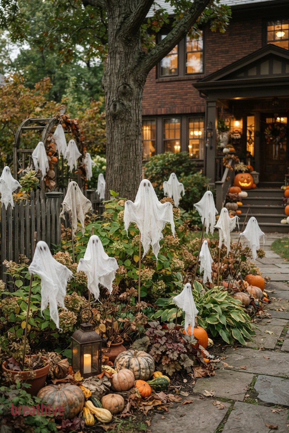 ghost-themed Halloween front yard idea with garden bed, tree, fence, or lawn edge with seasonal decor integrated into existing landscape