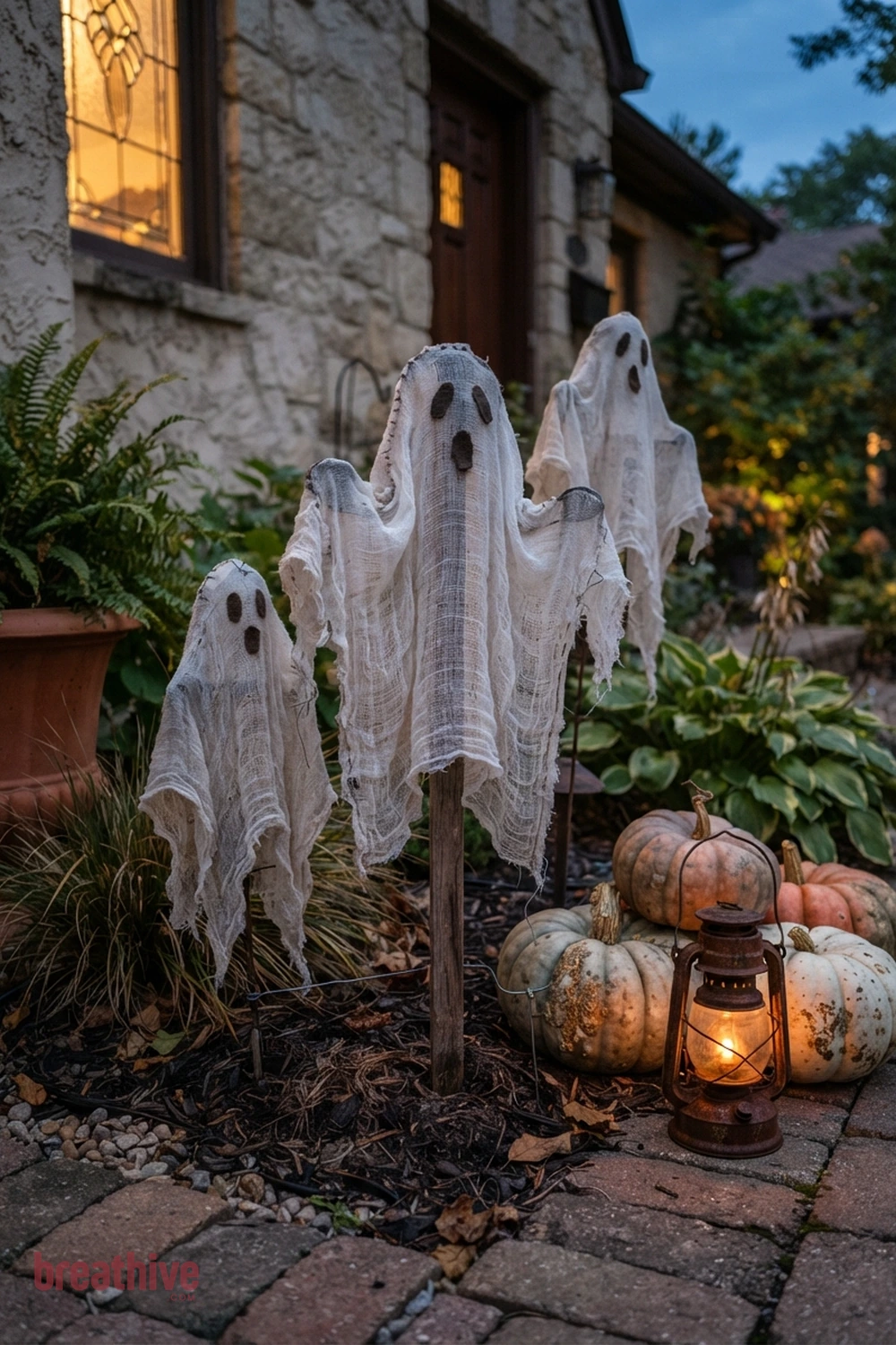 ghost-themed Halloween front yard idea with close view of one prop cluster showing texture, scale, anchoring, and relation to plants or hardscape